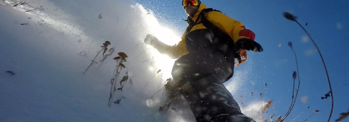 Jeremy Jensen surfing thru the snow and weeds without any bindings on his Grassroots Powsurfer