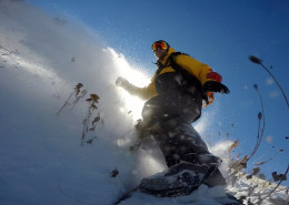 Jeremy Jensen surfing thru the snow and weeds without any bindings on his Grassroots Powsurfer